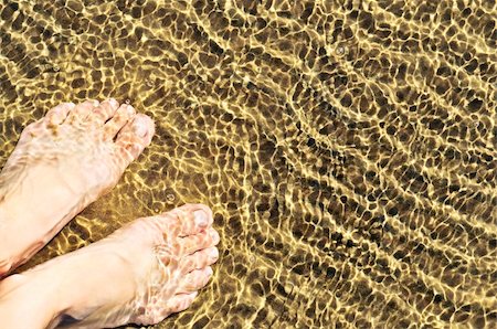 standing on toes - Bare feet wading in clear shallow water at sandy beach Stock Photo - Budget Royalty-Free & Subscription, Code: 400-05113155