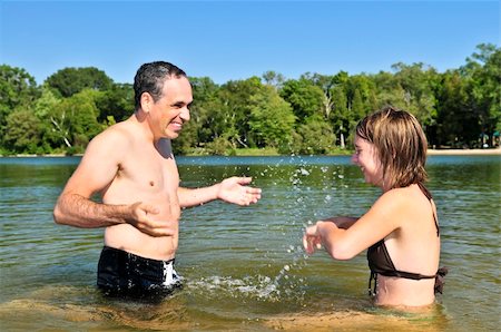 father daughter water splashing - Father and daughter splashing in a lake Stock Photo - Budget Royalty-Free & Subscription, Code: 400-05113953