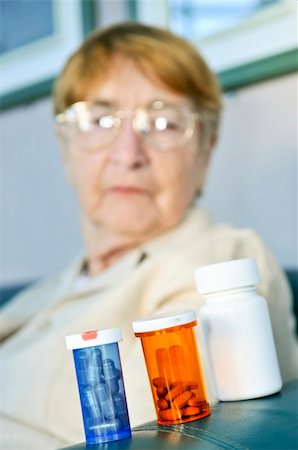 simsearch:400-06106335,k - Elderly woman sitting and looking at pill bottles Stock Photo - Budget Royalty-Free & Subscription, Code: 400-05113969