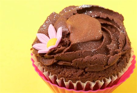 pink cupcake flowers - Miniature chocolate cupcake with icing and flower on yellow background Stock Photo - Budget Royalty-Free & Subscription, Code: 400-05125464