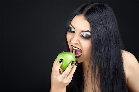 Brunette eating a green apple Stock Photo - Budget Royalty-Free & Subscription, Code: 400-05126153