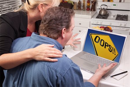 Couple In Kitchen Using Laptop with Yellow Oops Road Sign on the Screen. Stock Photo - Budget Royalty-Free & Subscription, Code: 400-05129327