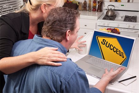 Couple In Kitchen Using Laptop with Yellow Success Road Sign on the Screen. Stock Photo - Budget Royalty-Free & Subscription, Code: 400-05129329