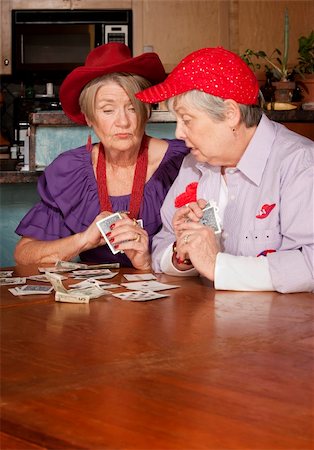 simsearch:400-04744719,k - Ladies wearing red hats playing a hand of cards Stock Photo - Budget Royalty-Free & Subscription, Code: 400-05121509
