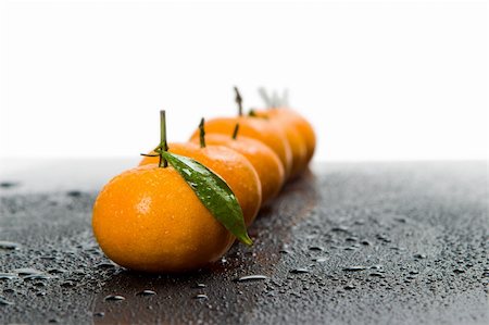 simsearch:400-07613620,k - Tangerines lie in a row on the black Stockbilder - Microstock & Abonnement, Bildnummer: 400-05121881