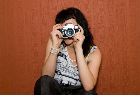 stylish woman snapshot - beauty girl shooting the retro camera on red wallpaper background Stock Photo - Budget Royalty-Free & Subscription, Code: 400-05123560