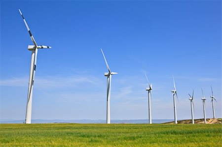 Wind turbines farm in green field over cloudy sky Stock Photo - Budget Royalty-Free & Subscription, Code: 400-05134654