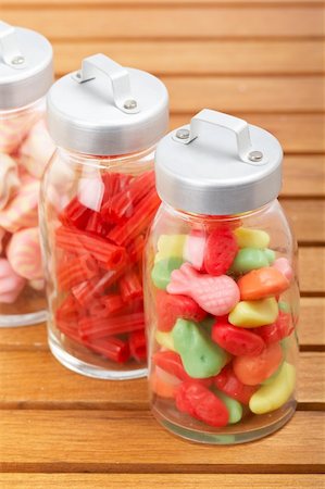 simsearch:400-04781520,k - Assortment of glass jars with marshmallows, candies and red licorice on wooden background. Shallow depth of field Photographie de stock - Aubaine LD & Abonnement, Code: 400-05135318