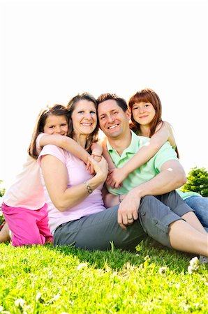 simsearch:400-04115211,k - Portrait of happy family of four sitting on grass at the park hugging Foto de stock - Super Valor sin royalties y Suscripción, Código: 400-05138435