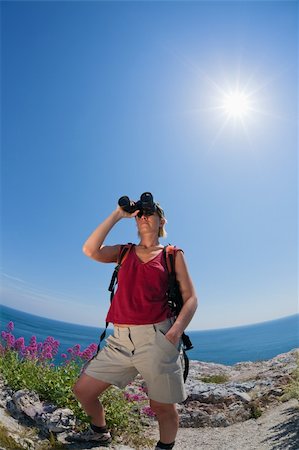 simsearch:400-04043242,k - young blonde woman hiking watching through binoculars. Copy space Photographie de stock - Aubaine LD & Abonnement, Code: 400-05138821