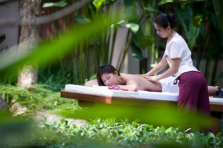 eastwestimaging (artist) - A young woman gets a massage outside in a tropical environment Foto de stock - Super Valor sin royalties y Suscripción, Código: 400-05139811