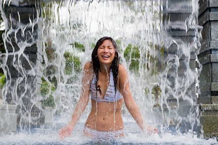 eastwestimaging (artist) - A young woman standing under a waterfall in a swimming pool Foto de stock - Super Valor sin royalties y Suscripción, Código: 400-05139826