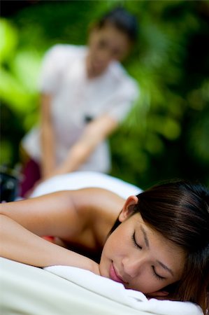 eastwestimaging (artist) - A young woman having massage outside in tropical garden Foto de stock - Super Valor sin royalties y Suscripción, Código: 400-05139820