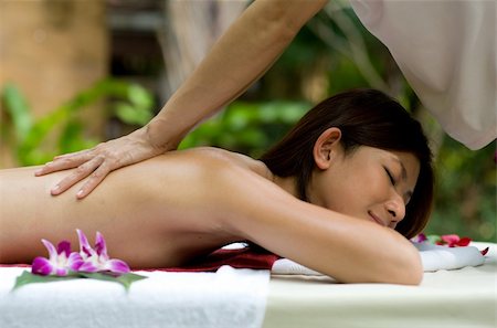 eastwestimaging (artist) - A young woman having a back massage outside in tropical setting Fotografie stock - Microstock e Abbonamento, Codice: 400-05139822