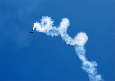 small plane in acrobatic flight with spiral trace over blue sky Foto de stock - Super Valor sin royalties y Suscripción, Código: 400-05131613