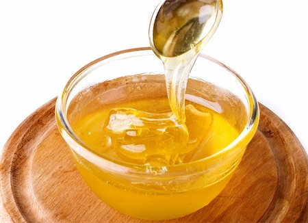 Thick sweet honey pouring from the spoon and into the small honey pot Stock Photo - Budget Royalty-Free & Subscription, Code: 400-05131687