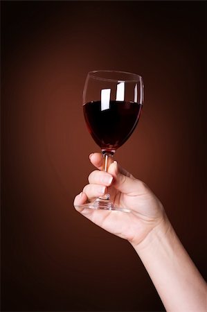 glass of red wine in hand on brown background Stock Photo - Budget Royalty-Free & Subscription, Code: 400-05131699