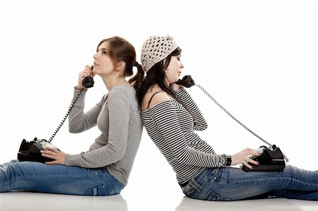 Two young women talking with old telephones - Isolated on white Stock Photo - Budget Royalty-Free & Subscription, Code: 400-05131837