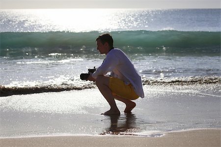 simsearch:400-04880707,k - The photographer with the camera on a coast on a decline Stock Photo - Budget Royalty-Free & Subscription, Code: 400-05146921