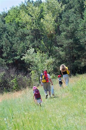 smiliHappy family hiking through the summer meadow to the wood. Stock Photo - Budget Royalty-Free & Subscription, Code: 400-05147508