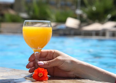 female hand holds a glass with juice in pool Stock Photo - Budget Royalty-Free & Subscription, Code: 400-05147598