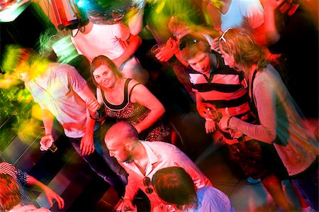 Girl smiling at the camera on a crowdy dance floor in a discotheque Stock Photo - Budget Royalty-Free & Subscription, Code: 400-05140056