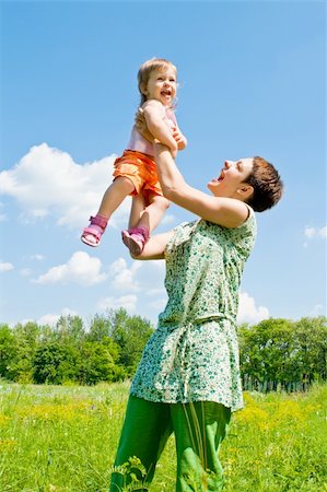 Mother raising baby girl up high Foto de stock - Super Valor sin royalties y Suscripción, Código: 400-05143272