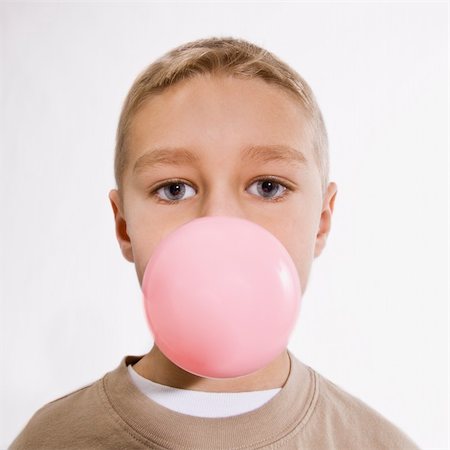 A young boy is chewing bubble gum and blowing a bubble.  He is looking at the camera.  Vertically framed shot. Stock Photo - Budget Royalty-Free & Subscription, Code: 400-05154010