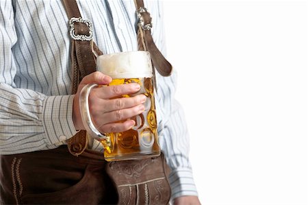 Bavarian man dressed with original leather trousers holds an Oktoberfest beer stein into the camera Stockbilder - Microstock & Abonnement, Bildnummer: 400-05154801