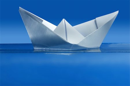 simsearch:400-04899558,k - Paper boat floating over blue real water, side view Fotografie stock - Microstock e Abbonamento, Codice: 400-05154825