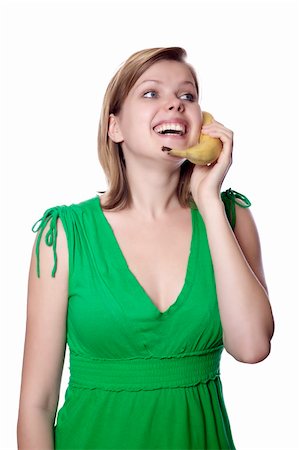 pretty women eating banana - Pretty girl in a green dress is holding a banana as a phone, isolated on white Stock Photo - Budget Royalty-Free & Subscription, Code: 400-05155582