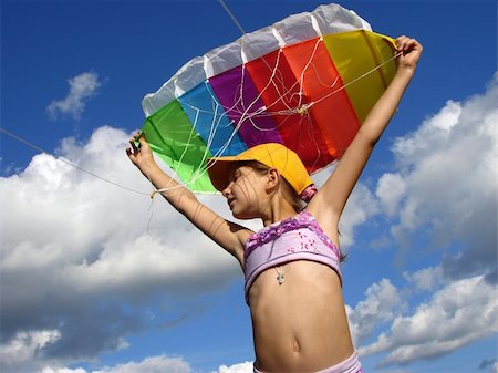 child starts flying kite against blue sky with clouds Stock Photo - Budget Royalty-Free & Subscription, Code: 400-05157579