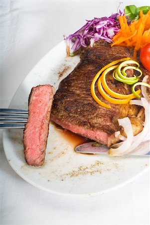 fresh juicy beef ribeye steak sliced ,with lemon and orange peel on top  and vegetable beside Stock Photo - Budget Royalty-Free & Subscription, Code: 400-05152449