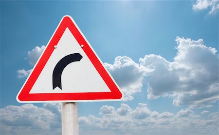 dangerous curve - Road turning right traffic sign against bright sky Stock Photo - Budget Royalty-Free & Subscription, Code: 400-05152698