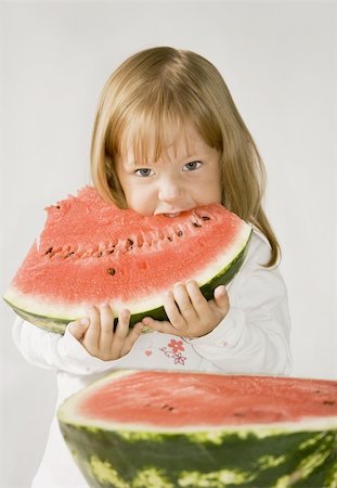 simsearch:400-07568470,k - Little girl holds a slice of the watermelon and eats his Stockbilder - Microstock & Abonnement, Bildnummer: 400-05164701