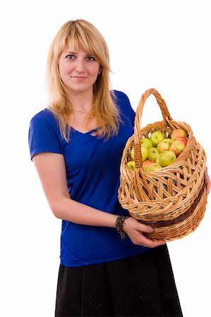 Woman in blue blouse standing and holding a basket full apples on white background. Beautiful girl holding a basket of delicious fresh fruits. Pretty girl with basket of apples. Isolated over white. Stock Photo - Budget Royalty-Free & Subscription, Code: 400-05165154