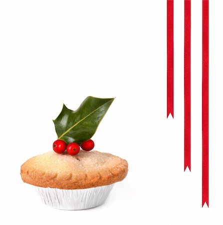 Mince pie topped with holly leaves with red berries, over white background with three red ribbons. Stock Photo - Budget Royalty-Free & Subscription, Code: 400-05166013