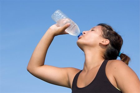 parched - Young athlete drinks water from a clear plastic bottle after a running exercise at an outdoor track. Stock Photo - Budget Royalty-Free & Subscription, Code: 400-05168402
