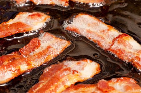 frying pan with bacon - A bacon cooking detail, slices of bacon in fat Stock Photo - Budget Royalty-Free & Subscription, Code: 400-05169323