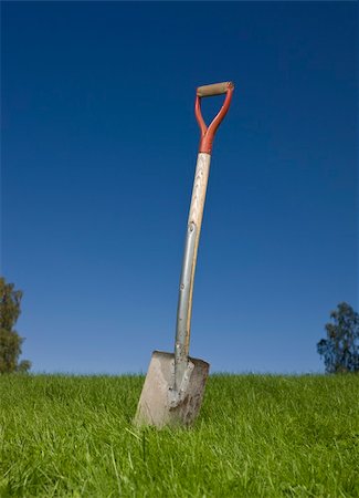 shovel in dirt - Shovel in green grass against a blue sky Foto de stock - Super Valor sin royalties y Suscripción, Código: 400-05169392