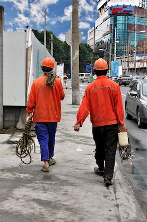 two construction workers leaving site with jogger in foreground Stock Photo - Budget Royalty-Free & Subscription, Code: 400-05169551