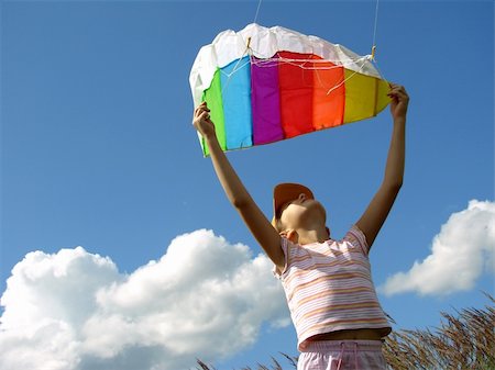 child starts flying kite against blue sky with clouds Stock Photo - Budget Royalty-Free & Subscription, Code: 400-05160489