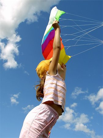 child starts flying kite against blue sky with clouds Stock Photo - Budget Royalty-Free & Subscription, Code: 400-05160490