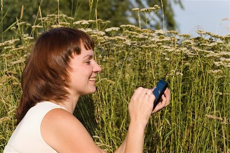 dmitrymik (artist) - Smiling woman with PDA in a meadow Stock Photo - Budget Royalty-Free & Subscription, Code: 400-05161612