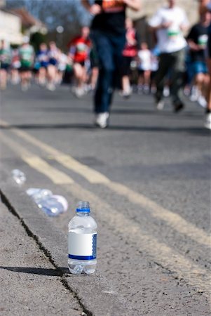 feet marathon - Focus on a bottle of water at a marathon with runners in the background Stock Photo - Budget Royalty-Free & Subscription, Code: 400-05161765
