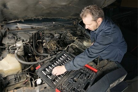 dirty overalls pictures - A mechanic repairing an engine of an old car. Stock Photo - Budget Royalty-Free & Subscription, Code: 400-05162142