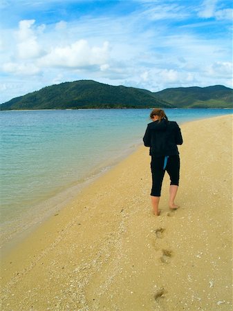 Girl walking on the beach searching for shells Stockbilder - Microstock & Abonnement, Bildnummer: 400-05163155