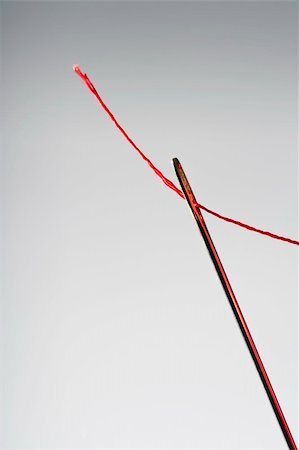 simsearch:400-07508563,k - macro image of needle and red thread against grey background Fotografie stock - Microstock e Abbonamento, Codice: 400-05177006