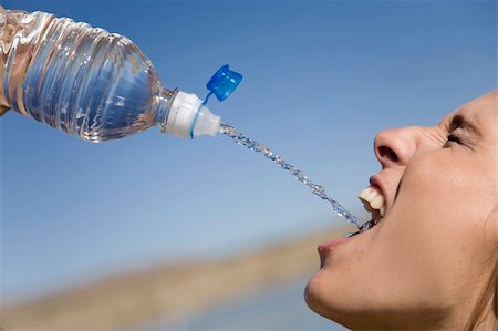 A woman squirting water into her mouth filling it full. Stock Photo - Budget Royalty-Free & Subscription, Code: 400-05177323