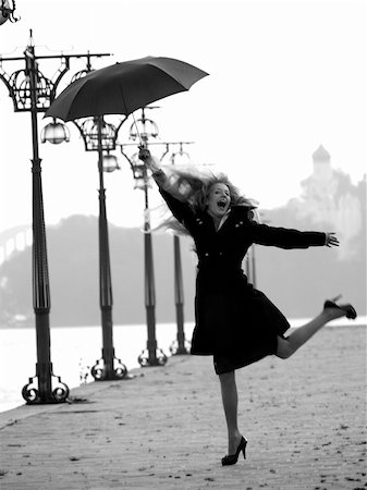 person falling in the wind - Weird blonde lady staying on promenade with umbrella Stock Photo - Budget Royalty-Free & Subscription, Code: 400-05177437